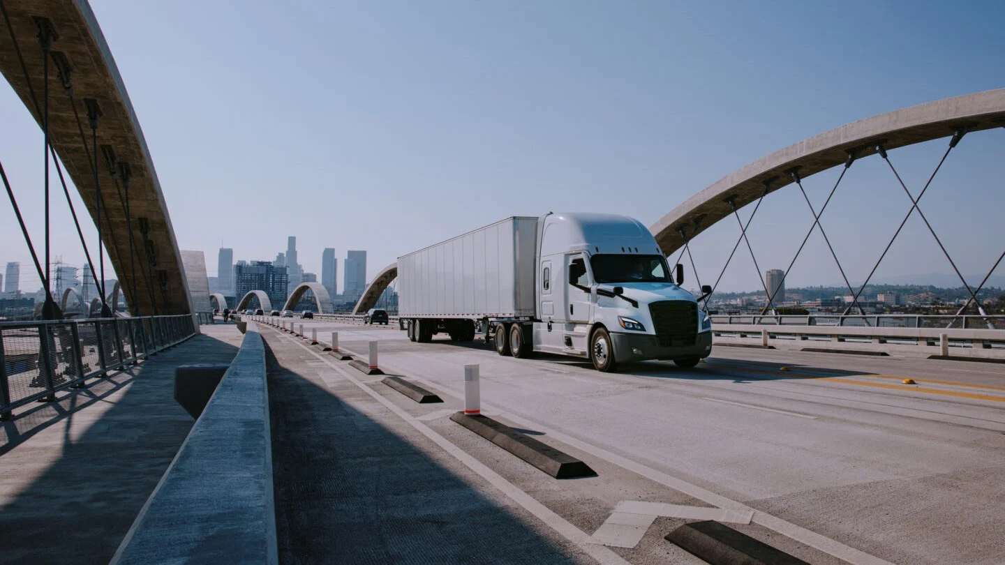 Truck driving over bridge.