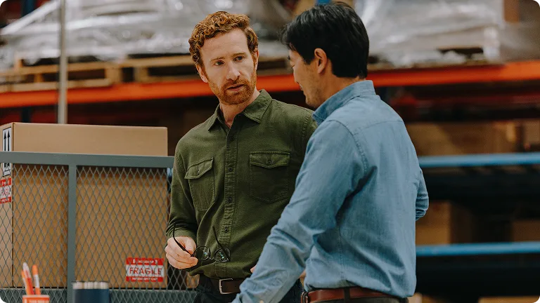 Two men talking in a warehouse